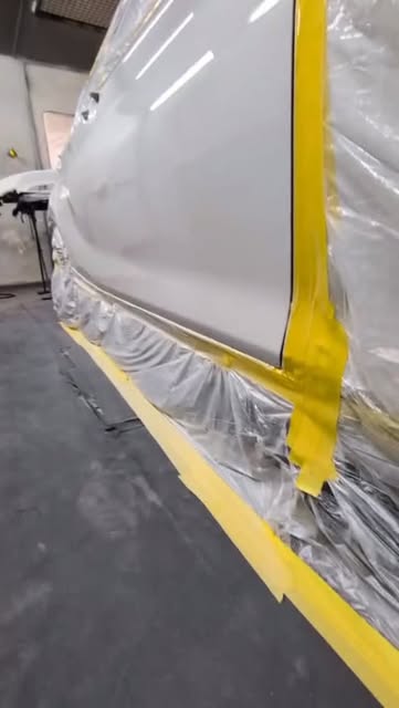 A panel masked off with yellow tape, ready for paint